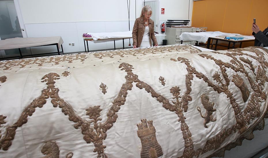 La consejera de Cultura contempla el terno blanco de la Virgen de los Reyes, pieza restaurada por el IAPH, en una imagen de archivo.