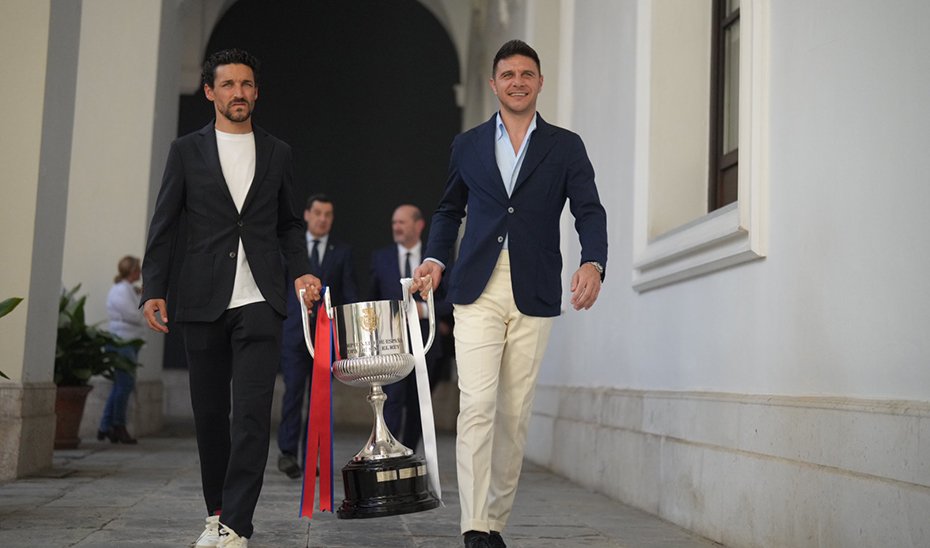 Jesús Navas and Joaquín Sánchez, former footballers of Sevilla FC and Real Betis Balompié, respectively, carry the Copa del Rey.
