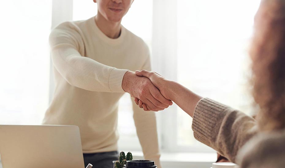 Letrado y cliente se dan la mano como muestra de acuerdo.