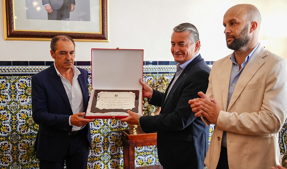 El consejero de la Presidencia, Antonio Sanz, recoge una placa conmemorativa en el acto celebrado en el Círculo Cultural Casino de Cazalla.